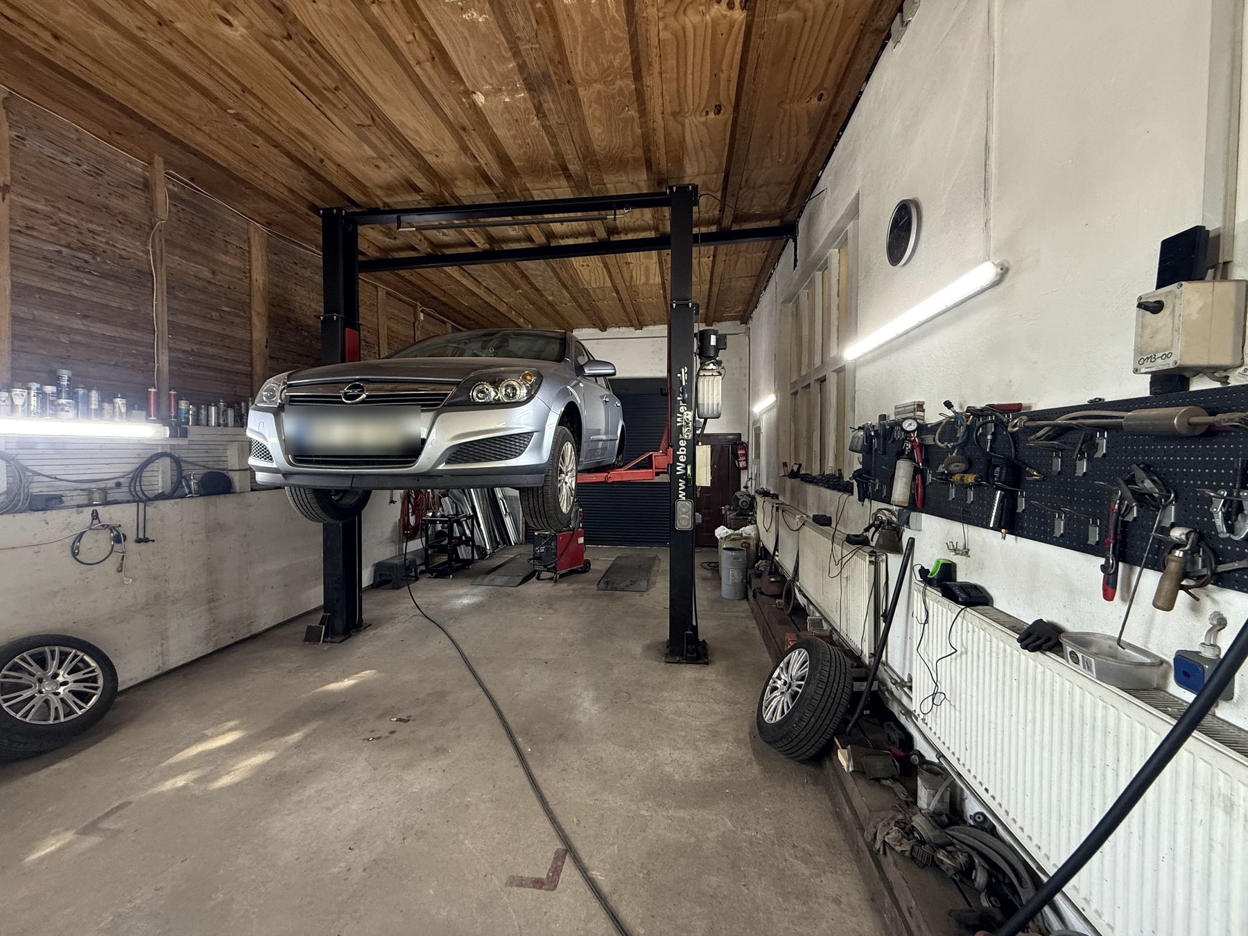 Werkstatthalle innen mit Auto auf der Hebebühne